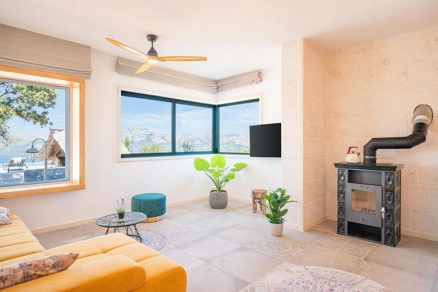 Ljust vardagsrum med öppen spis och panoramafönster