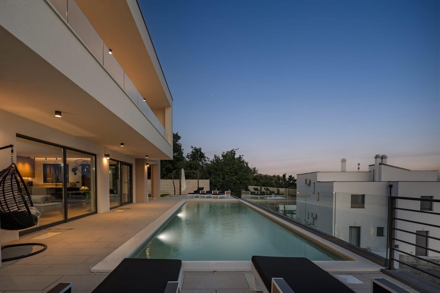 Modern villa med infinitypool och havsutsikt på kvällen