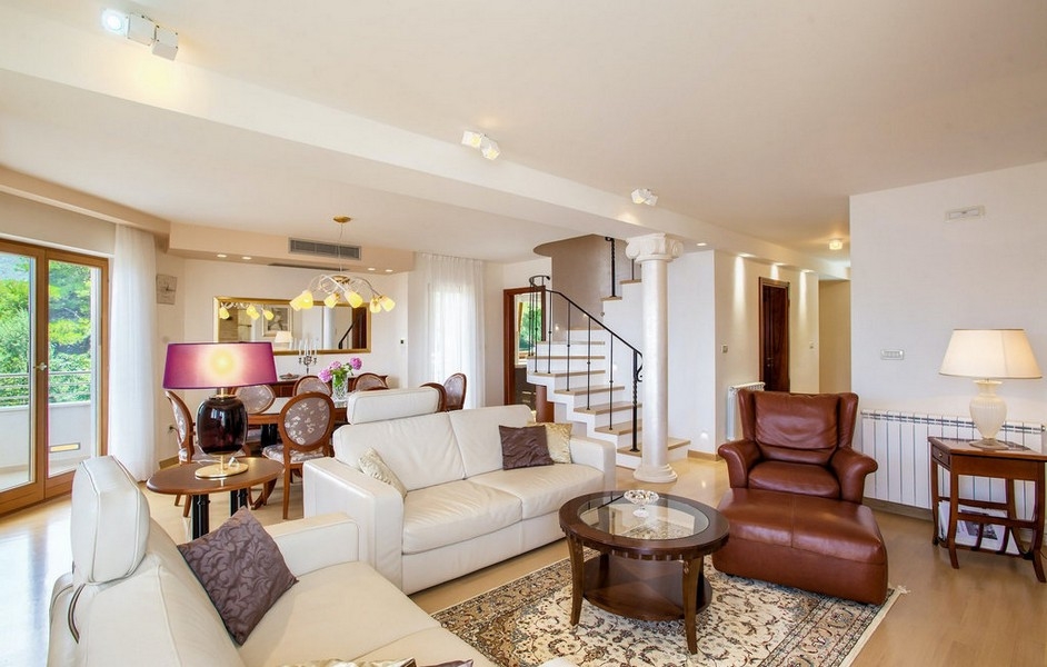 Ljust vardagsrum med soffgrupp och trappa