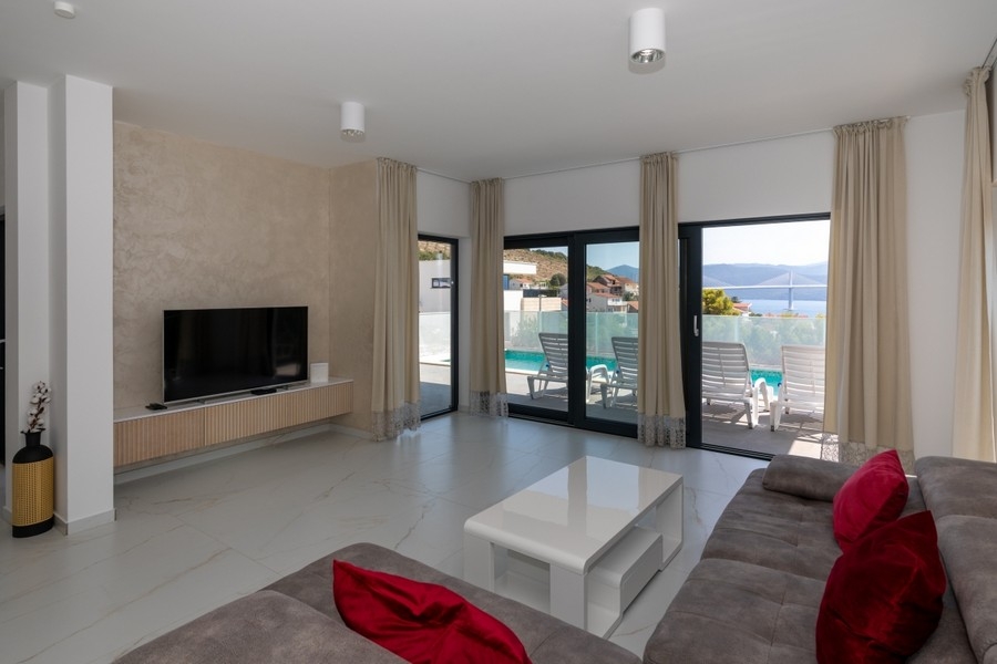 Modernt vardagsrum med utgång till terrassen och poolen