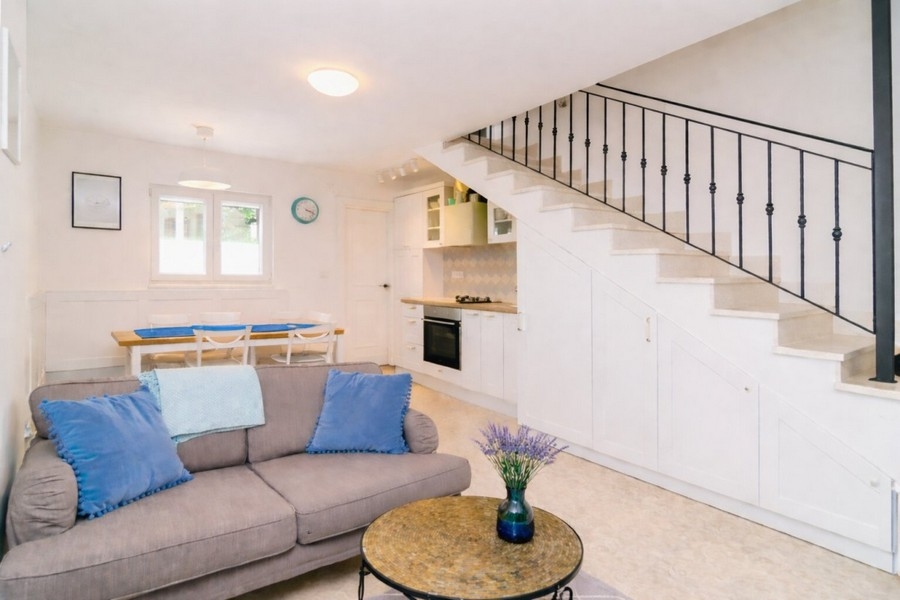 Öppet vardagsrum med kök och trappor