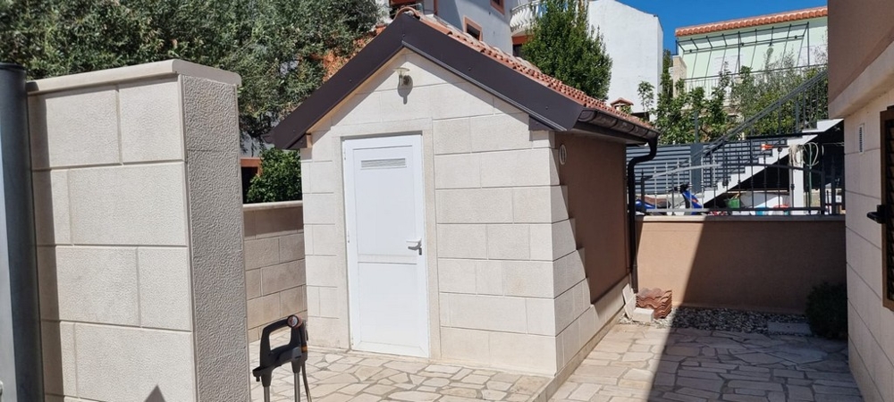 Uthus på gården med förrådsutrymme och välskött uteplats