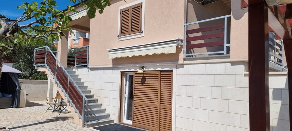 Husfasad med balkong, markiser och separata ingångar till bostäderna