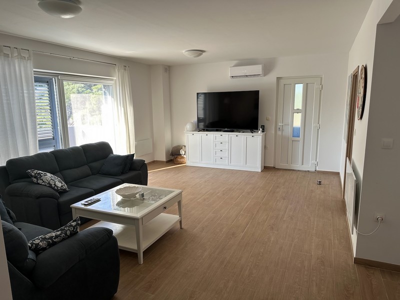 Vardagsrum med soffa, TV och tillgång till balkong med modern inredning