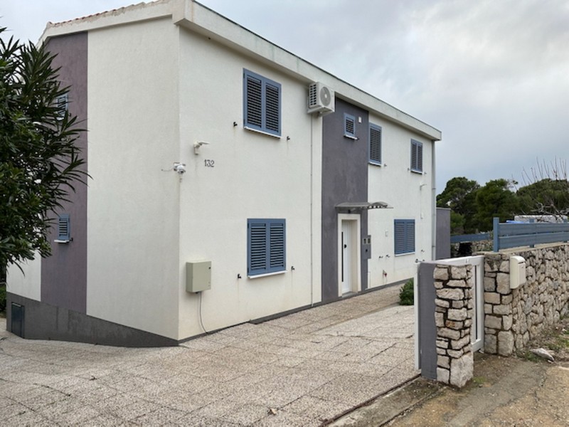 Husfasad med entré och parkeringsplats på inhägnad fastighet i Kroatien