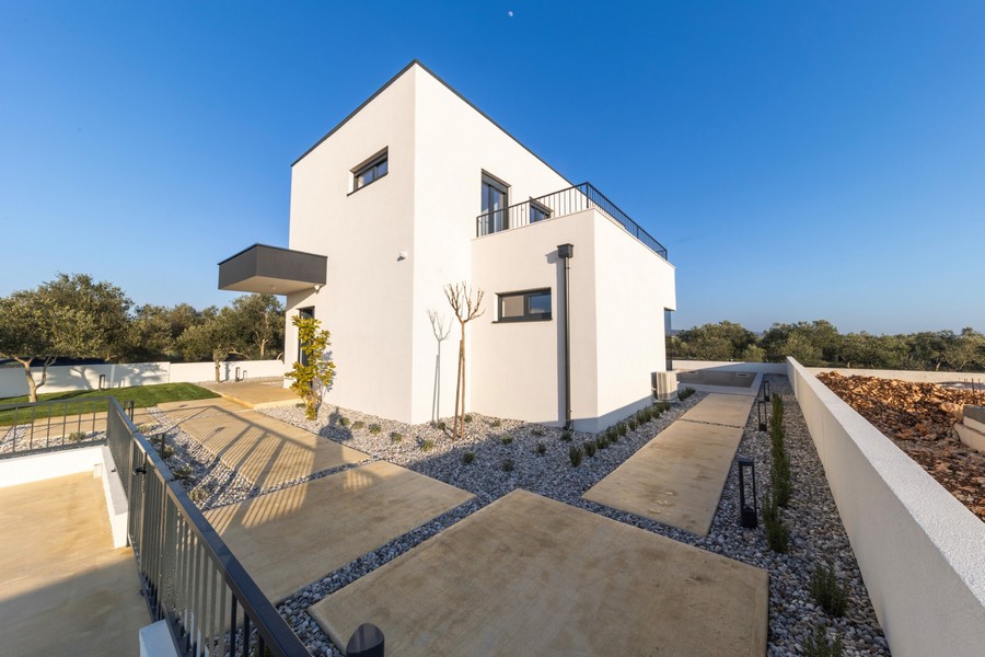 Modernt enfamiljshus med tydlig arkitektur och välvårdad uteplats