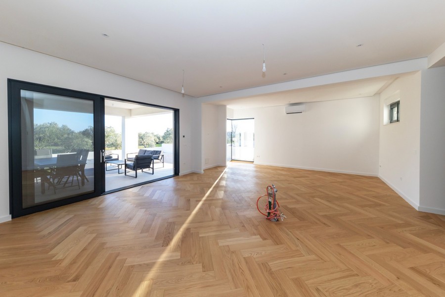 Öppet vardagsrum med stora fönster och utgång till terrassen