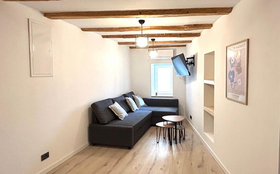 Vardagsrum med soffa och takbjälkar