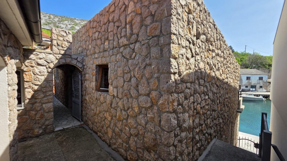 Naturstenshus med tillgång och utsikt över vattnet