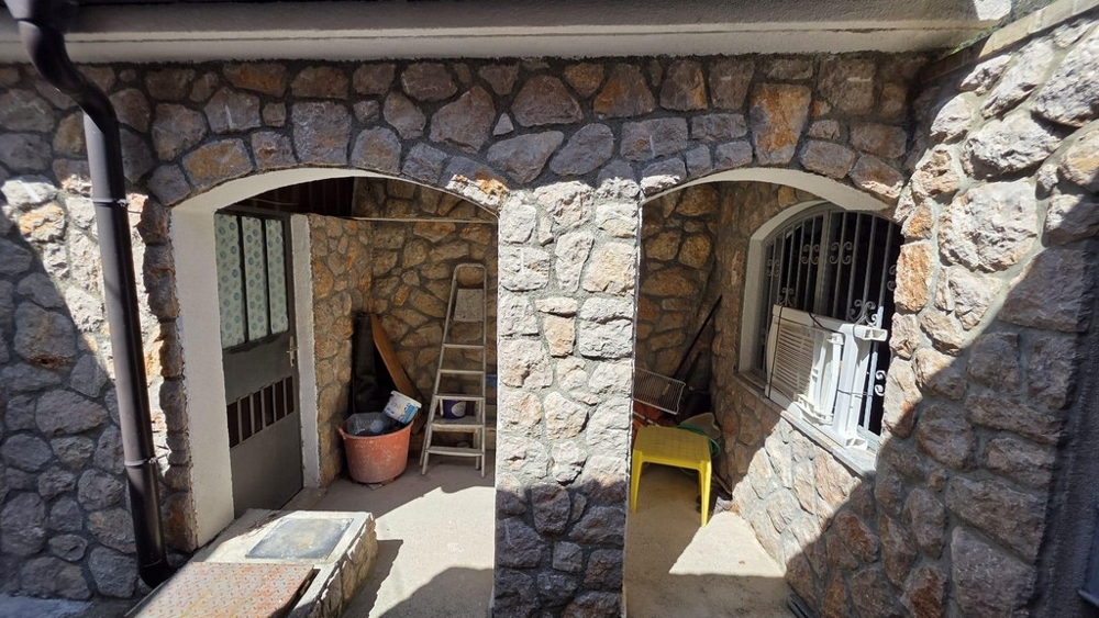 Täckt entréparti med naturstensfasad och valv