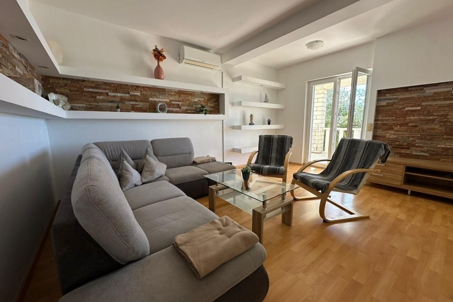 Vardagsrum med soffa, fåtölj och modern väggdesign