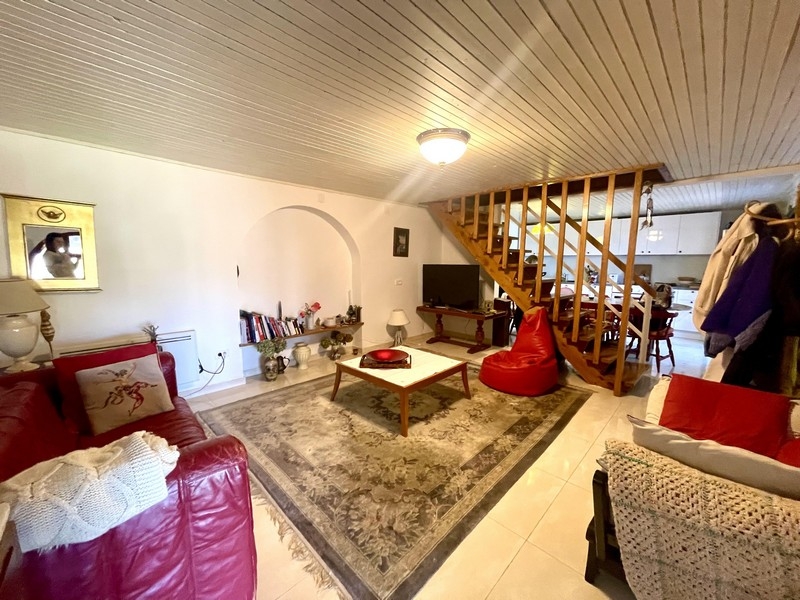 Vardagsrum med soffa, matta och öppen trappa