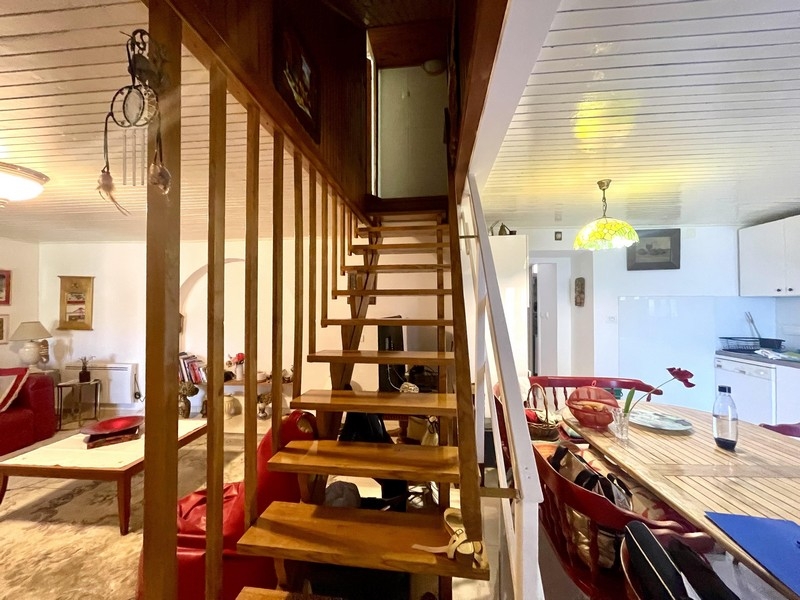 Öppet vardagsrum med trappa och kök