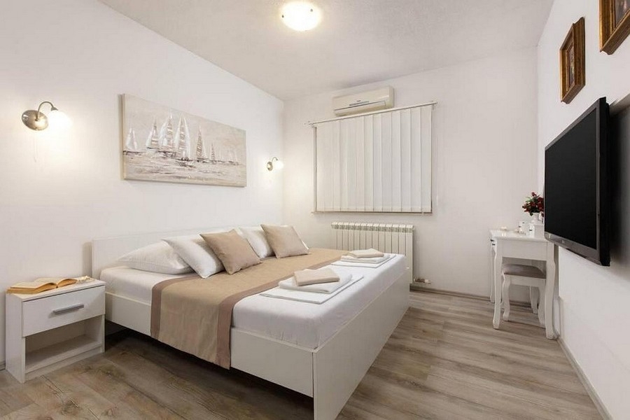 Modernt inrett sovrum med luftkonditionering och TV