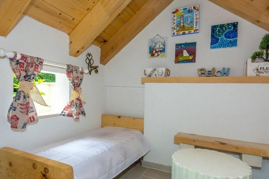 Sovplats på vinden med träbjälkar och mysig atmosfär