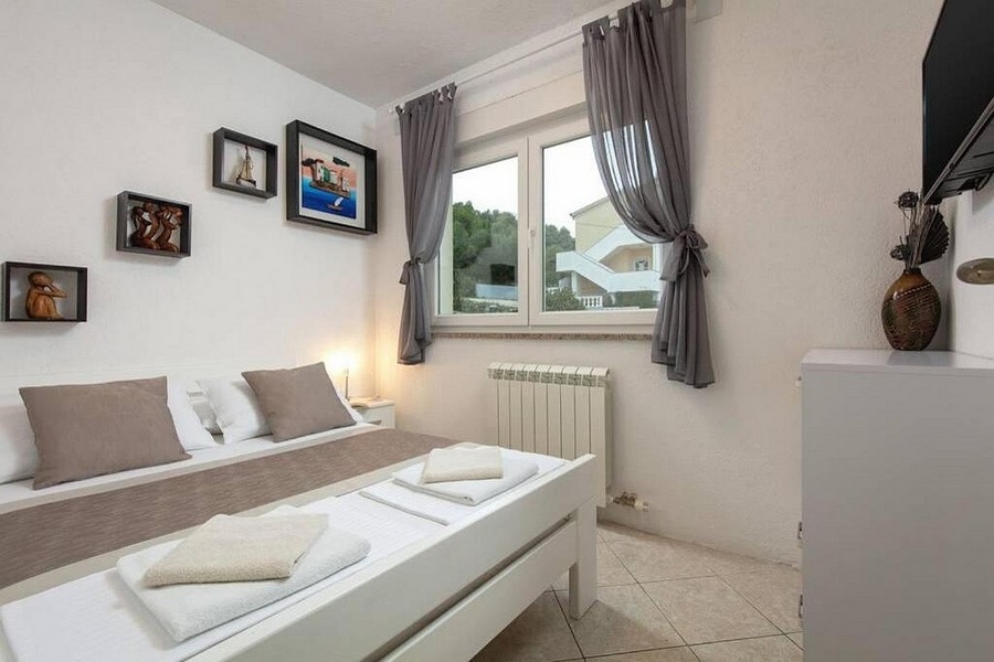 Sovrum med dubbelsäng och fönster med utsikt över grönskan