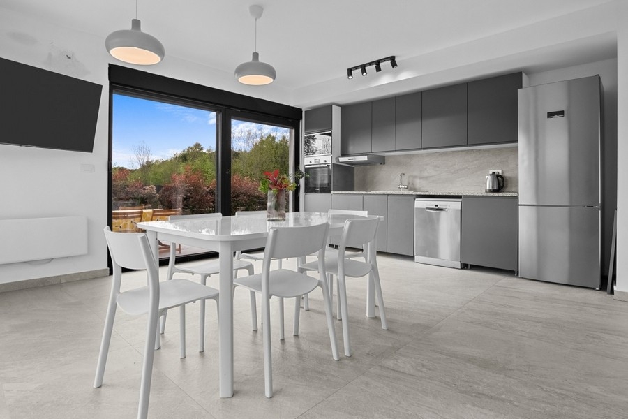 Modernt vardagsrum och matplats med öppet kök och tillgång till terrassen