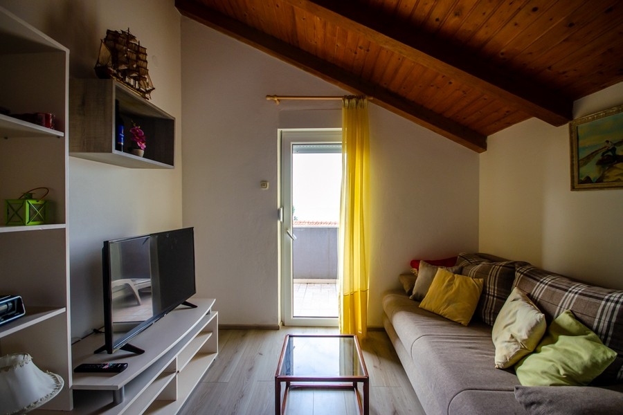 Vardagsrum på vinden med soffa och utgång till balkong