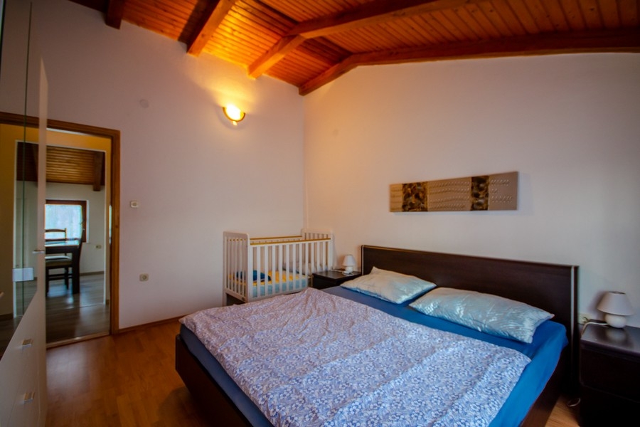 Sovrum med dubbelsäng och takbjälkar