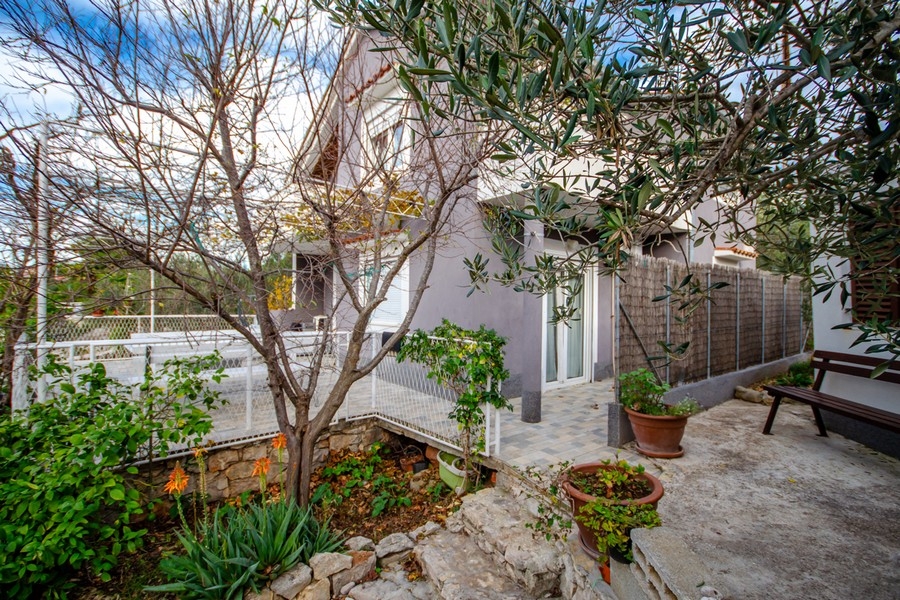 Rymlig terrass med sittgrupp och pergola utanför