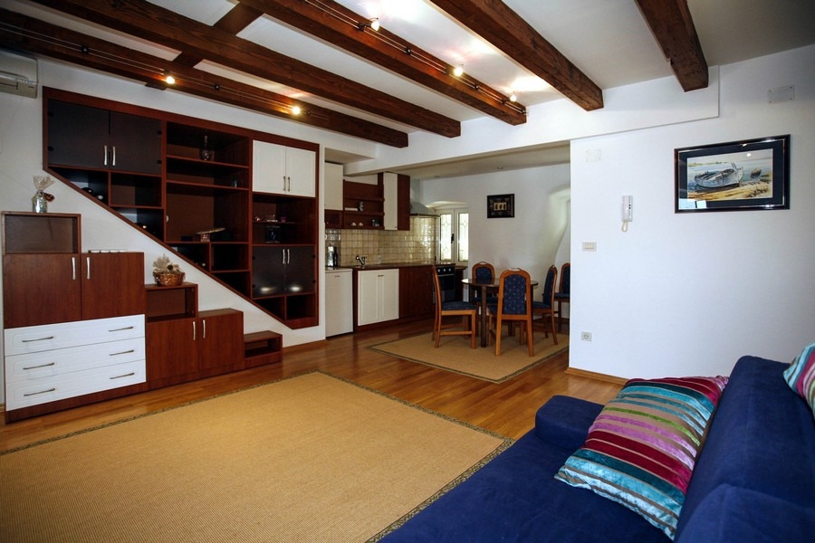 Vardagsrum med öppet kök och synliga träbjälkar