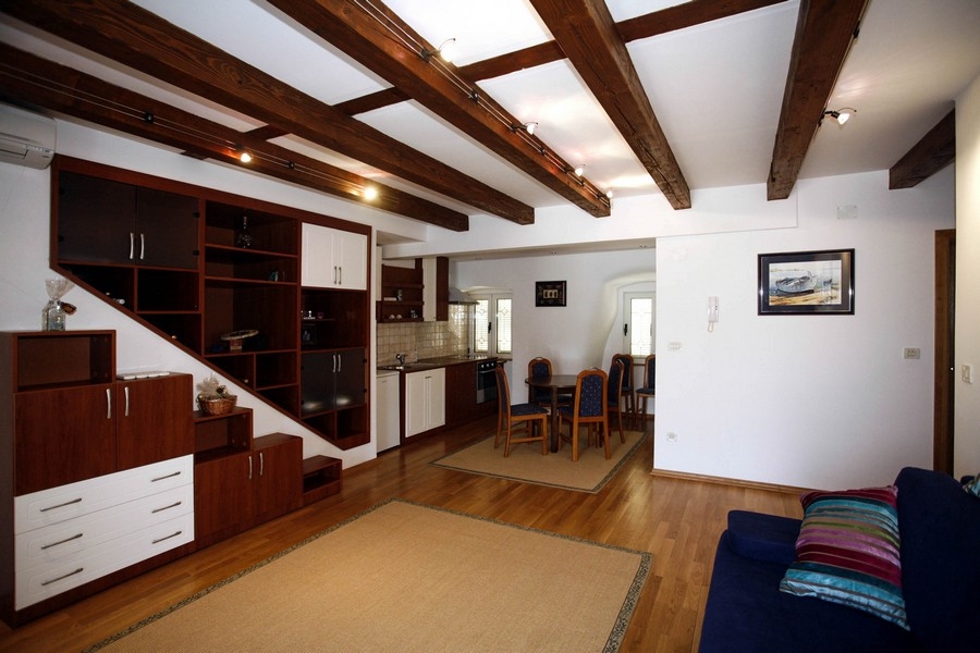 Öppet vardagsrum med kök och trätak