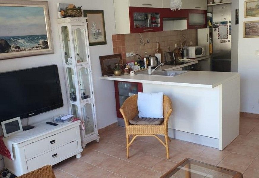 Öppet vardagsrum med kök och bänk