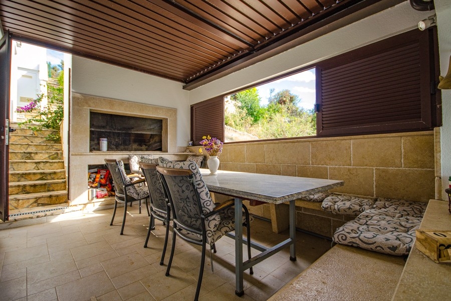 Täckt uteområde med sommarkök och grillplats