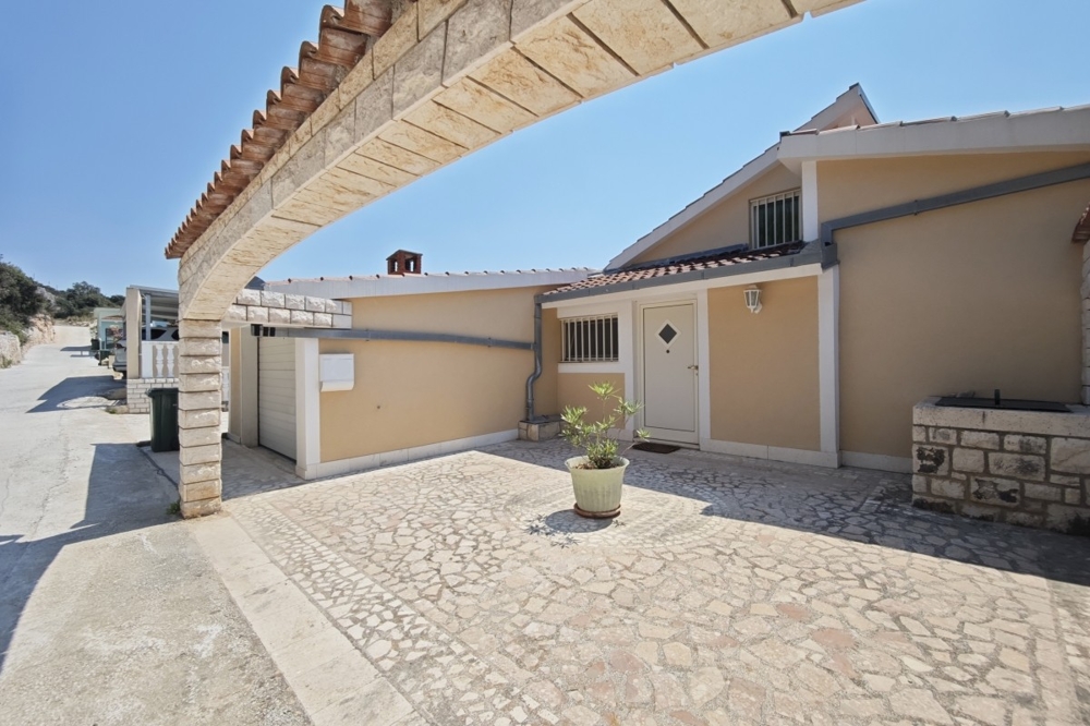 Husfasad med garage och stenlagd gård