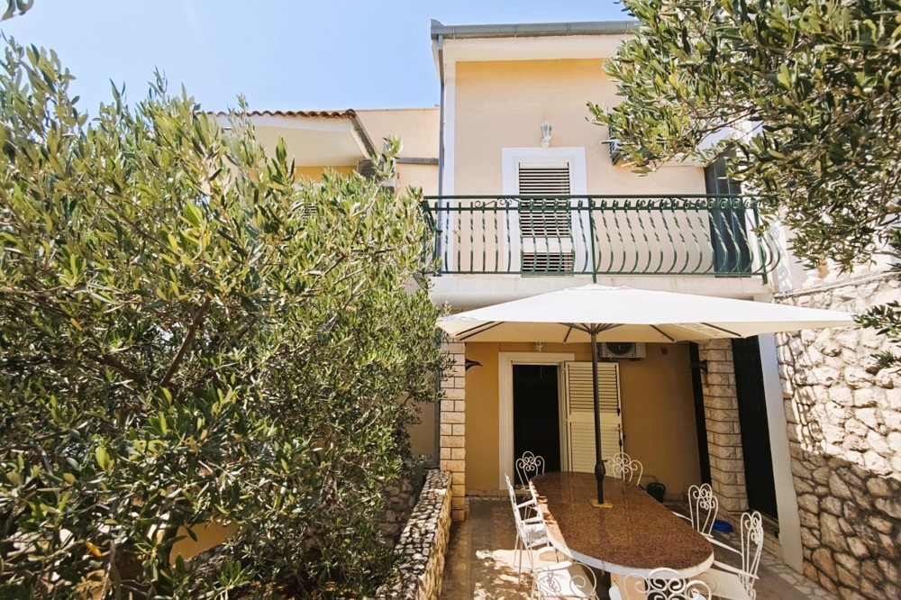 Täckt terrass med sittgrupp och olivträd