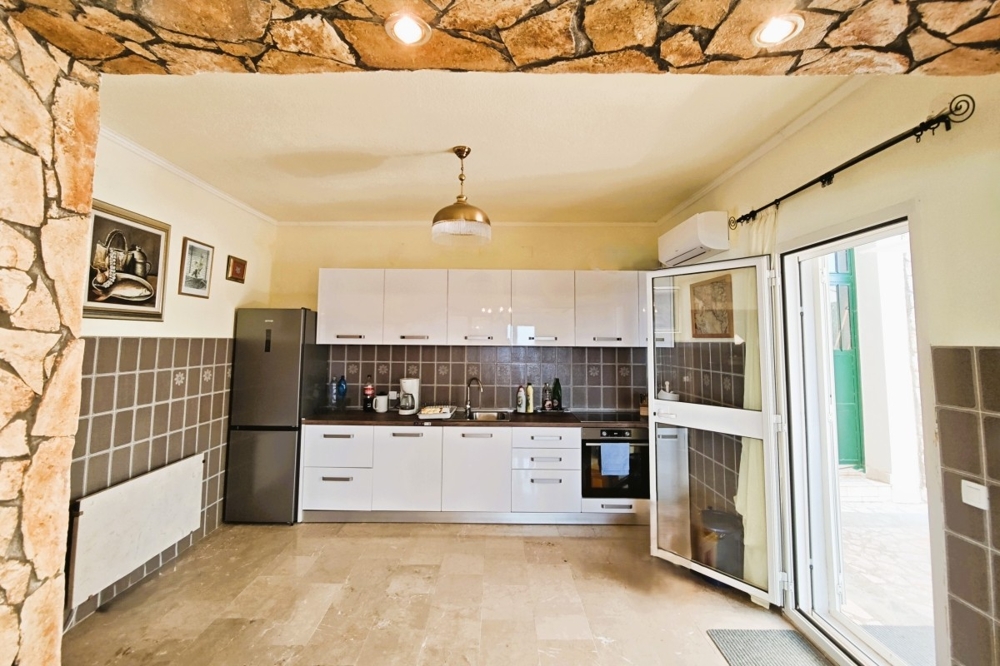 Kök-vardagsrum med utrustat kök och utgång till terrassen