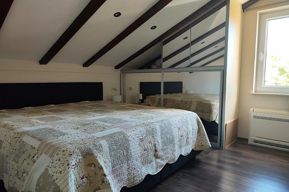 Sovrum på vinden med synliga träbjälkar