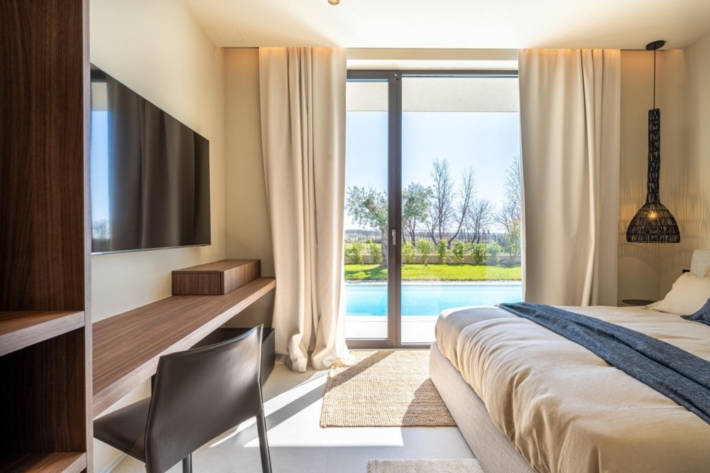 Sovrum med direkt utsikt över trädgården och poolen