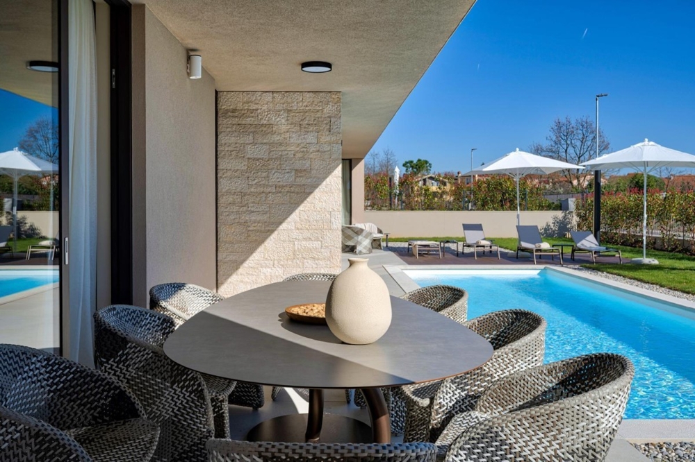 Modern terrass med matbord och pool