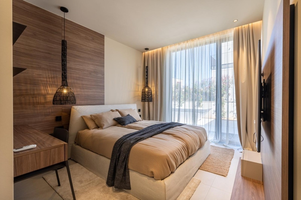 Sovrum med stora fönster och gardiner