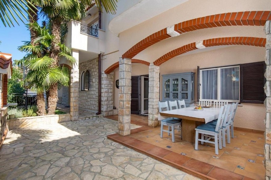 Övertäckt terrass med sittgrupp och naturstensfasad