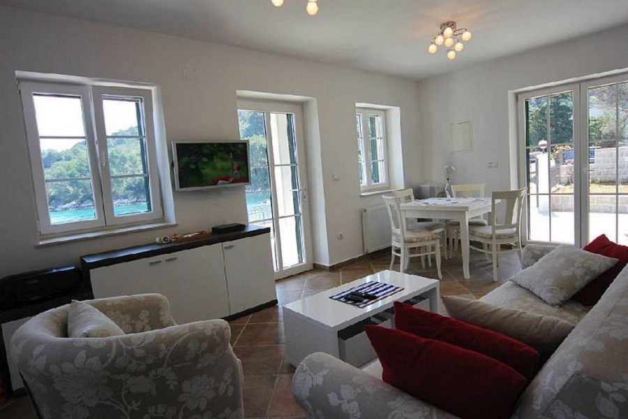 Ljust vardagsrum med stora fönster och havsutsikt