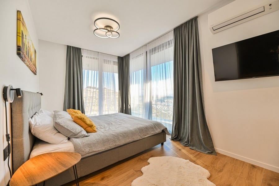 Sovrum med fönster från golv till tak och utsikt