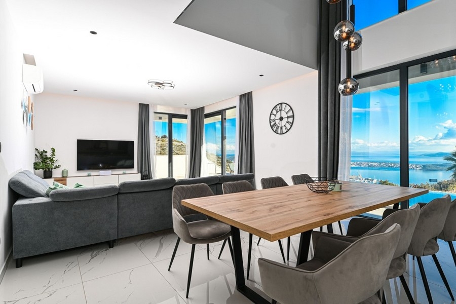 Öppen vardagsrumsdel med matbord och havsutsikt