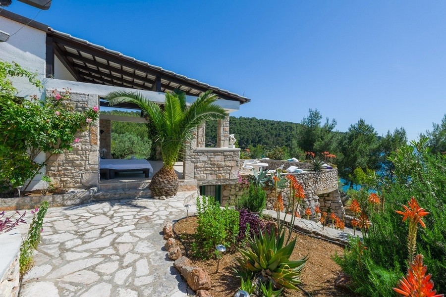 Medelhavsstenhus med utsikt över trädgården och havet