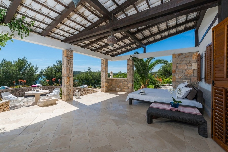 Täckt terrass med lounge och havsutsikt