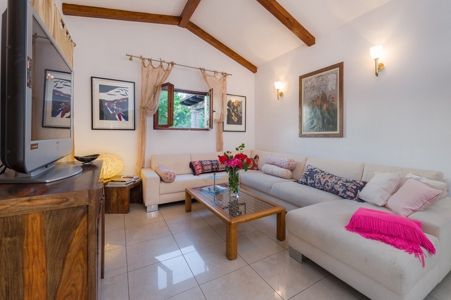 Vardagsrum med träbjälkar och ljus inredning