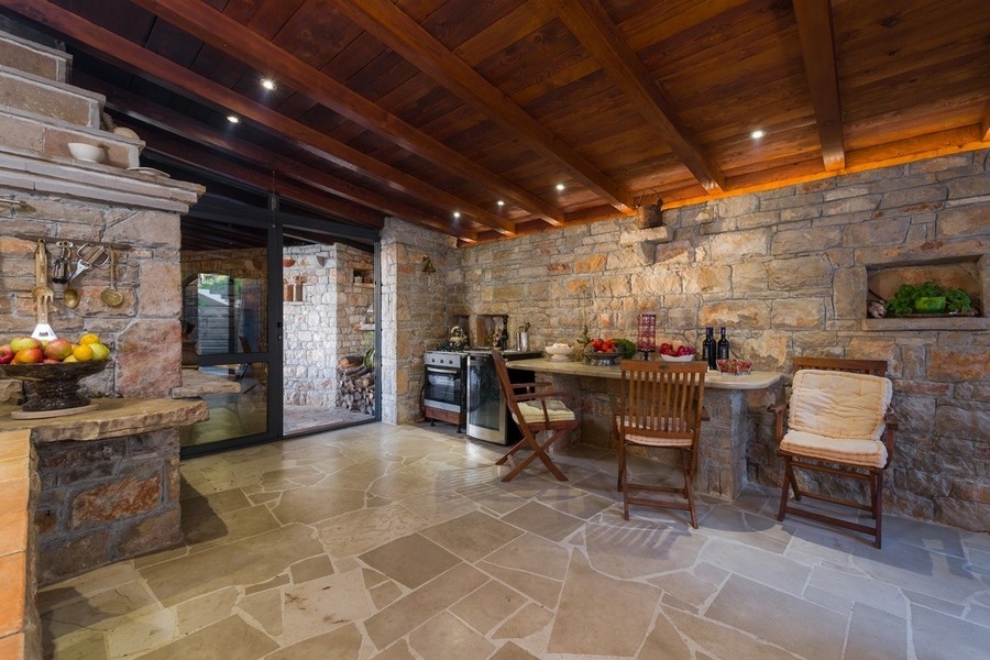 Rustikt kök med naturstensväggar och trätak