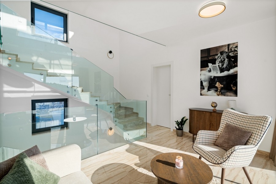 Elegant loungedel med glasräcken och modern inredning