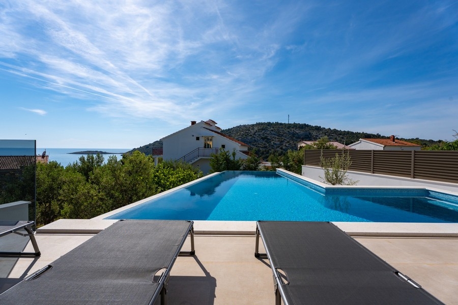 Infinitypool med havsutsikt framför modern villa i Dalmatien