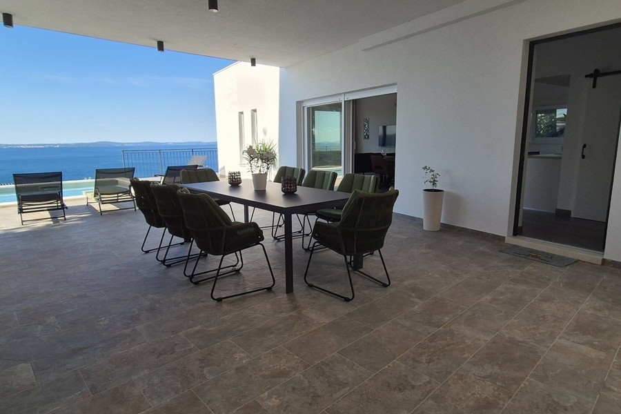 Rymlig terrass med pool och lounge vid havet