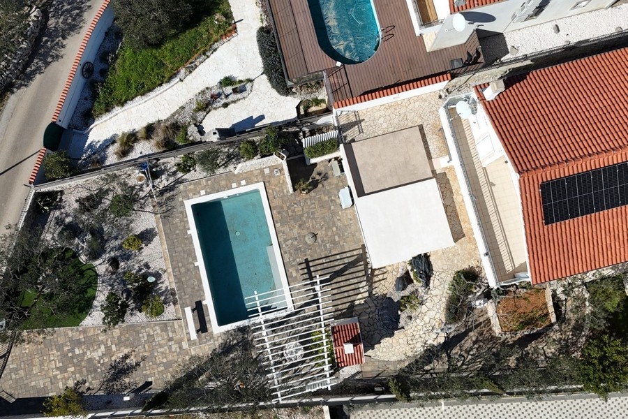 Flygfoto med poolterrass och trädgård
