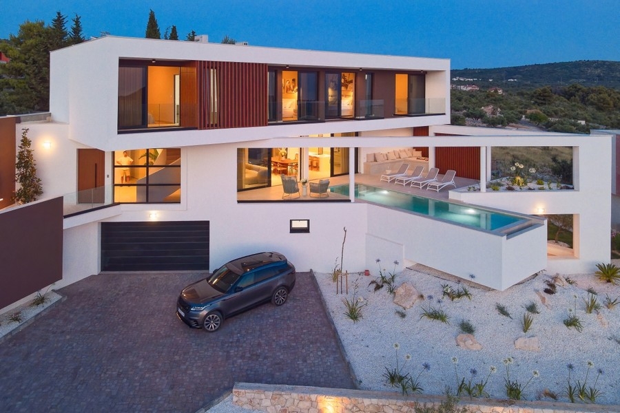 Upplyst villa med pool på kvällen