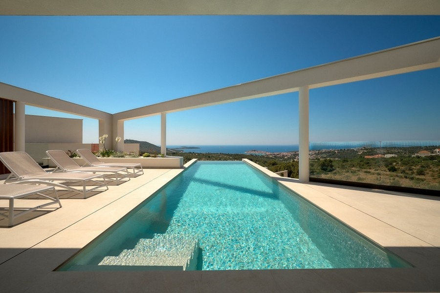 Solterrass med infinitypool och panoramautsikt över havet