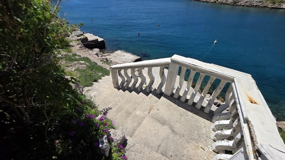 Stentrappa med balustrad till havet